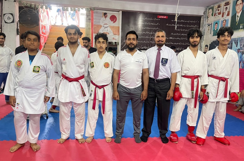 Championship kumite fighters with official tournament referee and coach